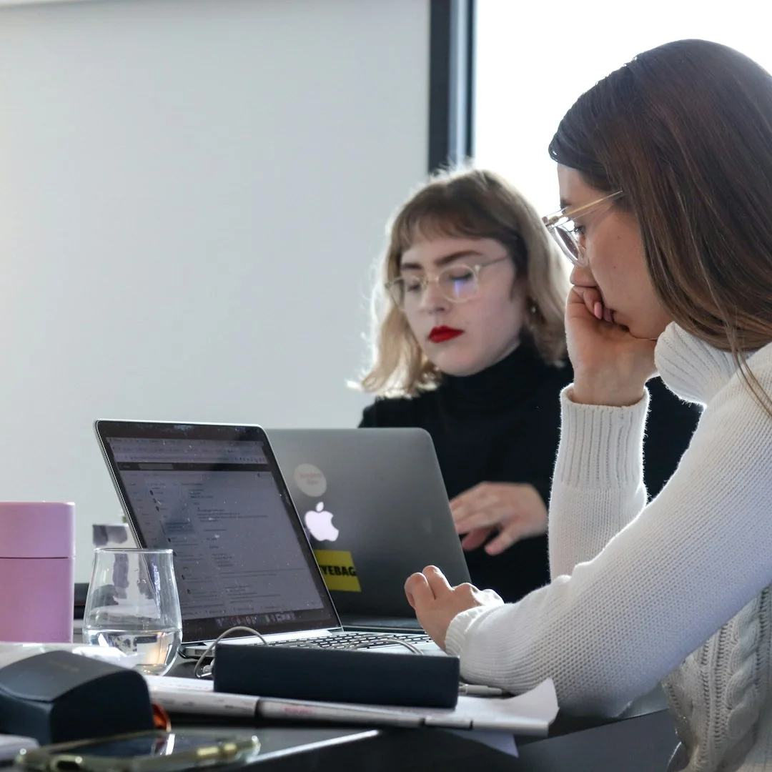 A diverse team collaborating on digital marketing strategies at a desk, using laptops and tablets.